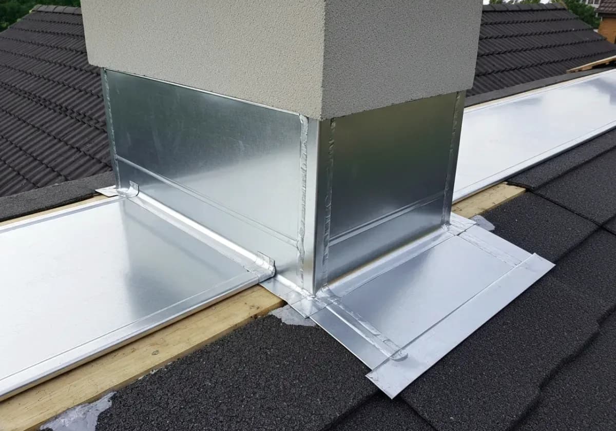After — chimney flashing repair: Failed roof-to-chimney flashing stripped, re-stepped and sealed watertight.