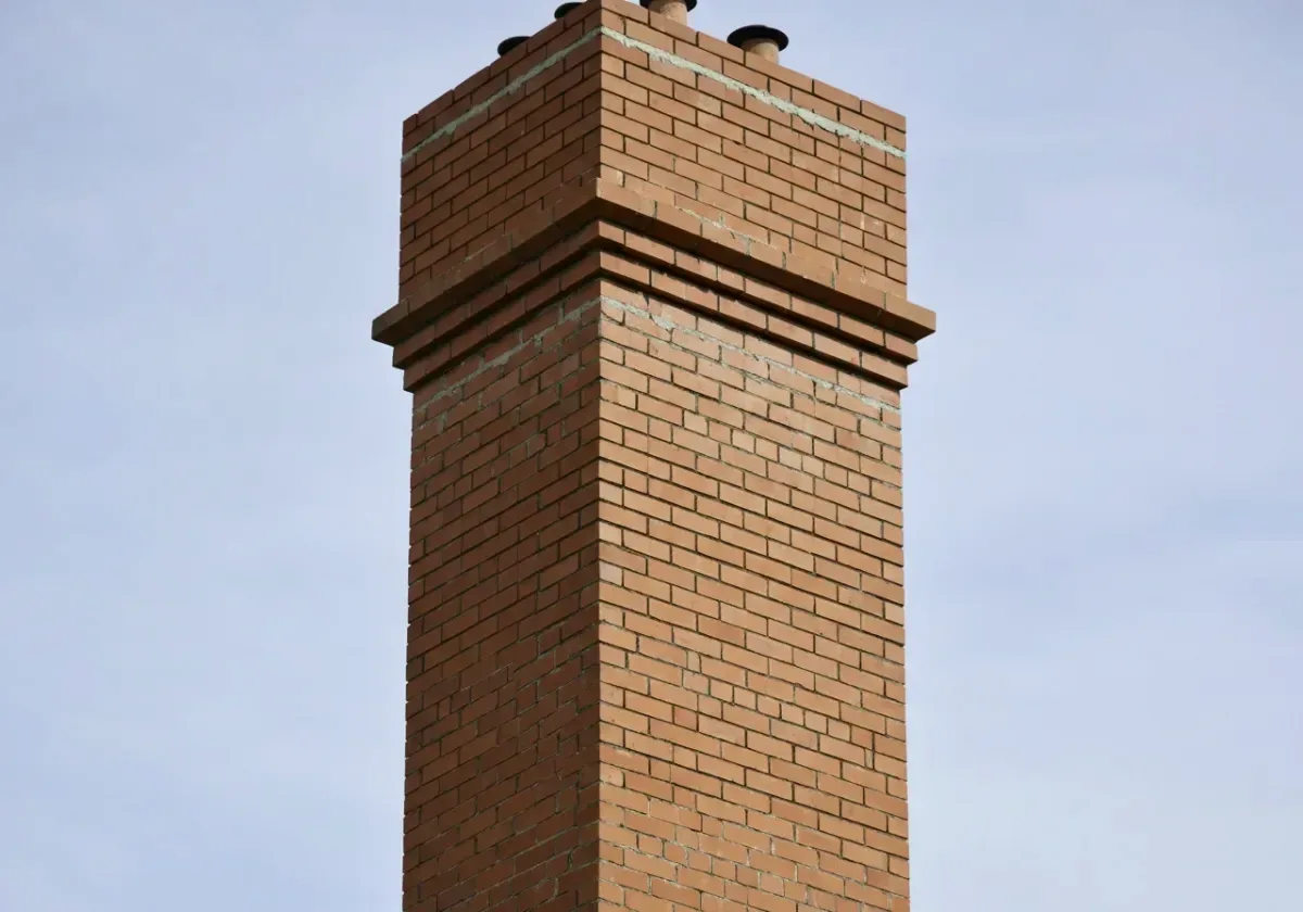 After — chimney repair: Spalled courses and washed-out joints rebuilt to a weather-tight stack.